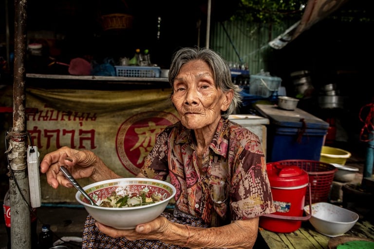 Elderly Thai woman eating street food
