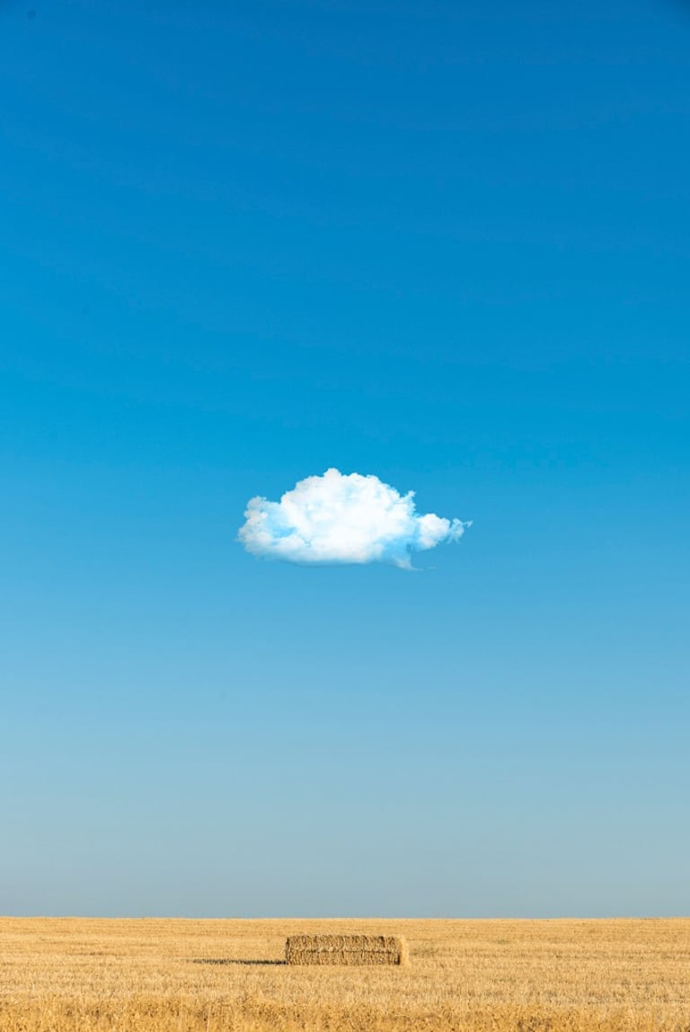 Fardo paja en campo con nube y cielo azul