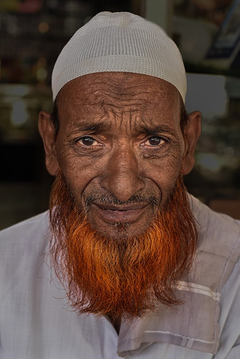 Hombre indio con barba naranja y taqiyah