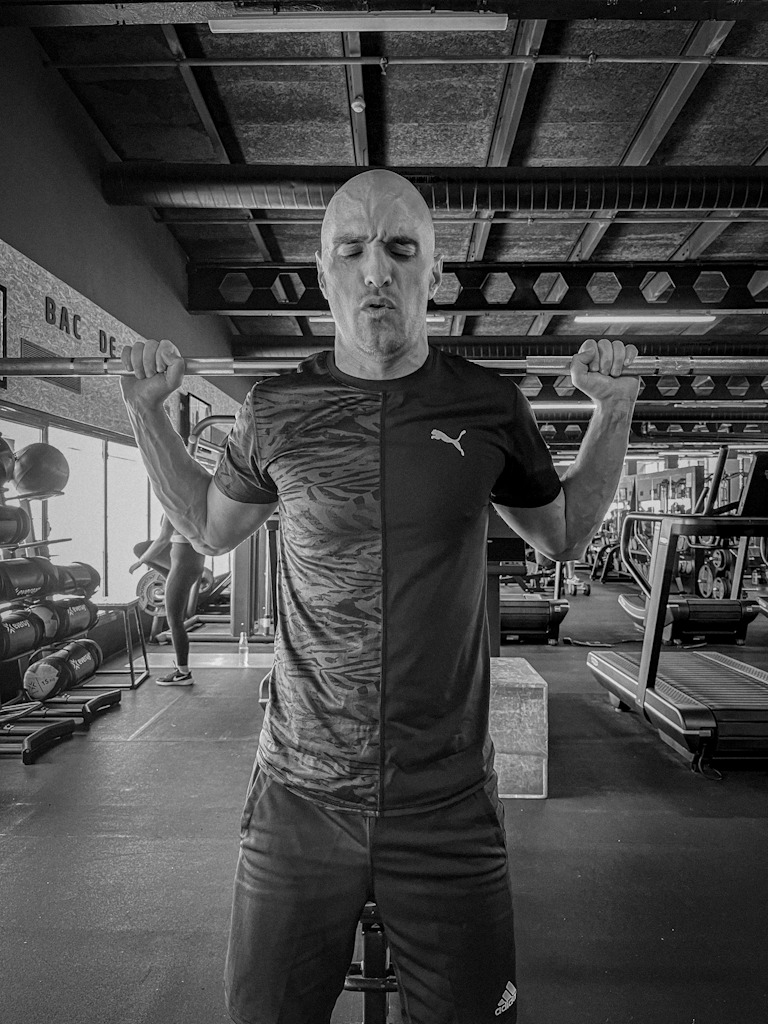 Man training in the gym with a strained expression