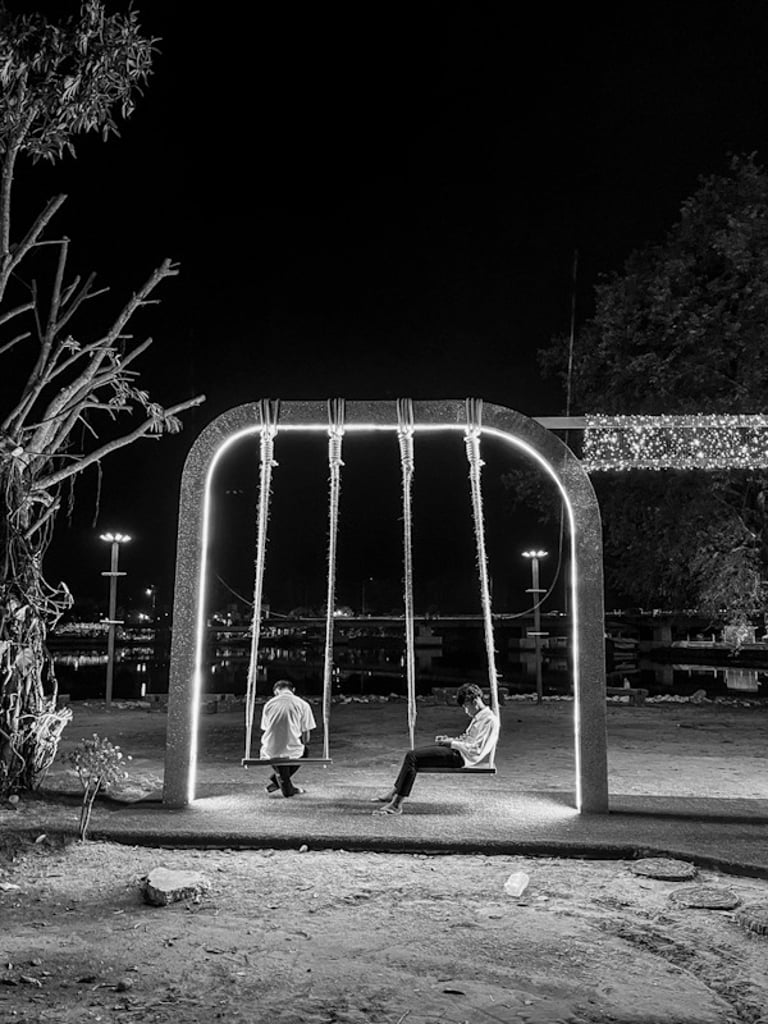 Thai children with their mobile phones on a swing