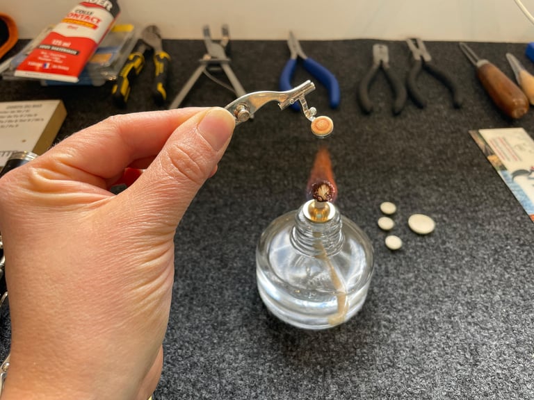 gros plan sur une main chauffant un piston de flûte traversière pour le réparer