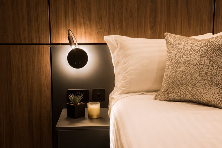 Close up section of a built in bedside cabinet with the reading light on