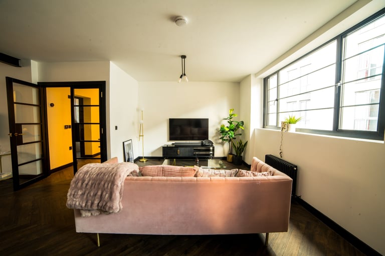 Behind a sofa looking onto the TV of a living room apartment