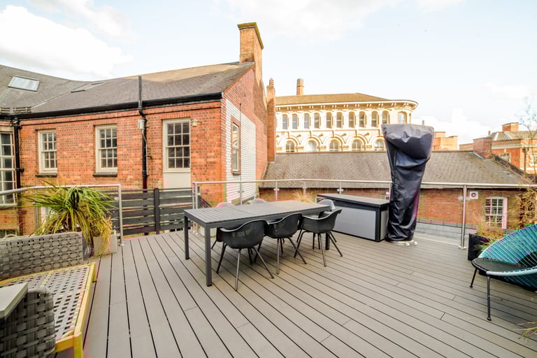 Standing from one side of a balcony looking onto the seating area and space with views of the city