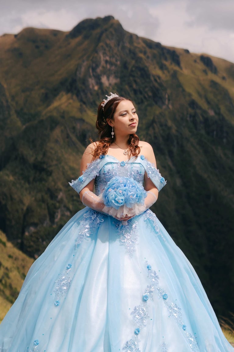 Sesión de fotos de quinceañera con vestido azul, ramo de flores en la montaña de Quito Ecuador