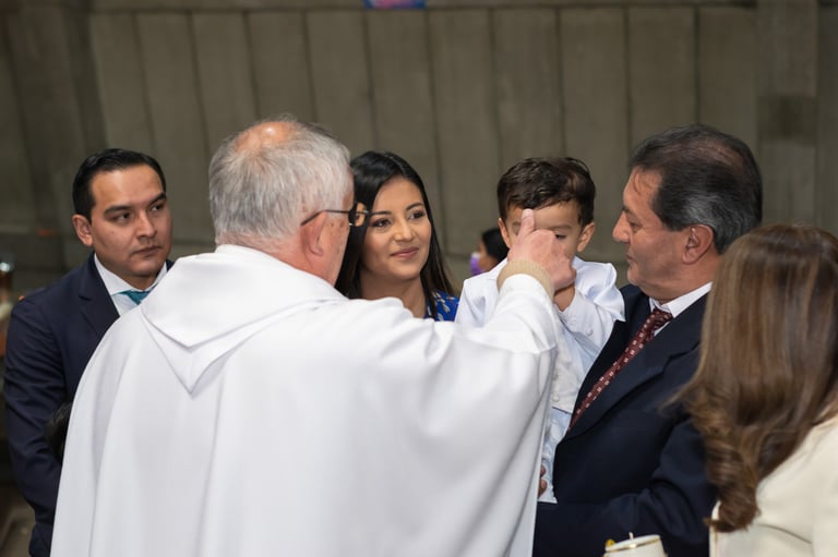Niño recibiendo el sacramento de bautizo por el padre foto profesional Ecuador