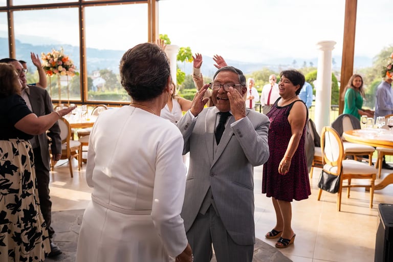 Hombre mayor vestido de traje viendo a su esposa en una boda de oro mientras bailan en Quito