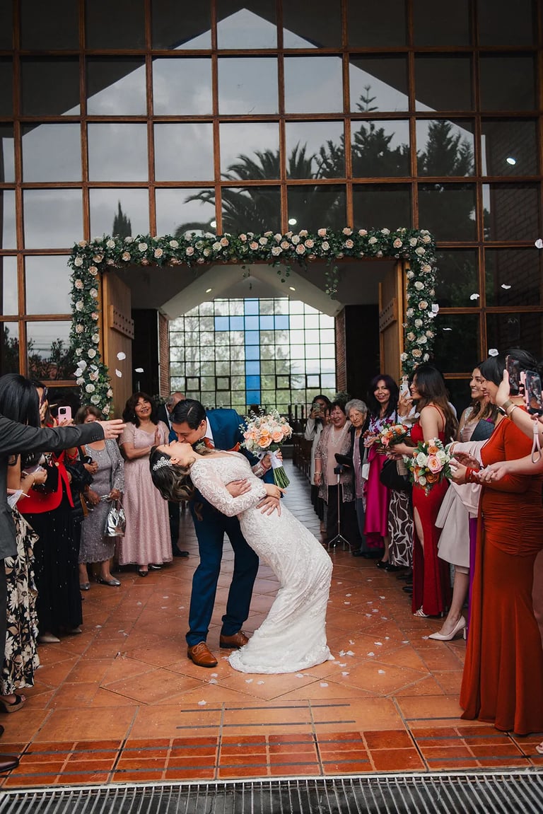 Recién casados dandose un beso de amor en su boda en Tumbaco Quito