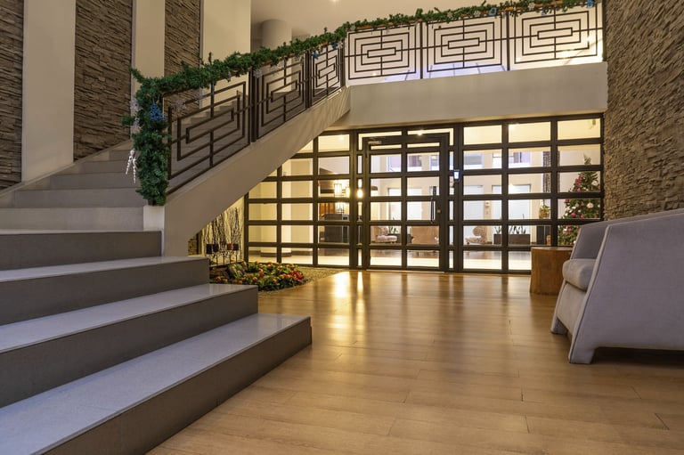 fotografía inmobiliaria en quito ecuador edificio metroplaza sala de estar con muebles y escaleras iluminación