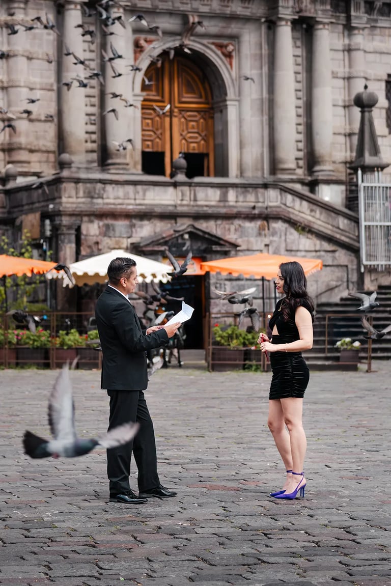Hombre con terno negro leyendo una carta con amor a su novia vestida de negro con palomas volando alrededor