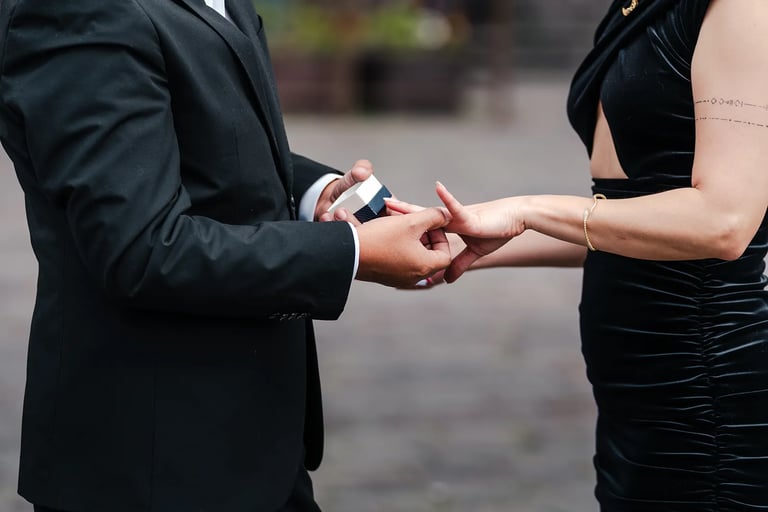 Plano detalle de novio colocándole el anillo a su novia en el dedo