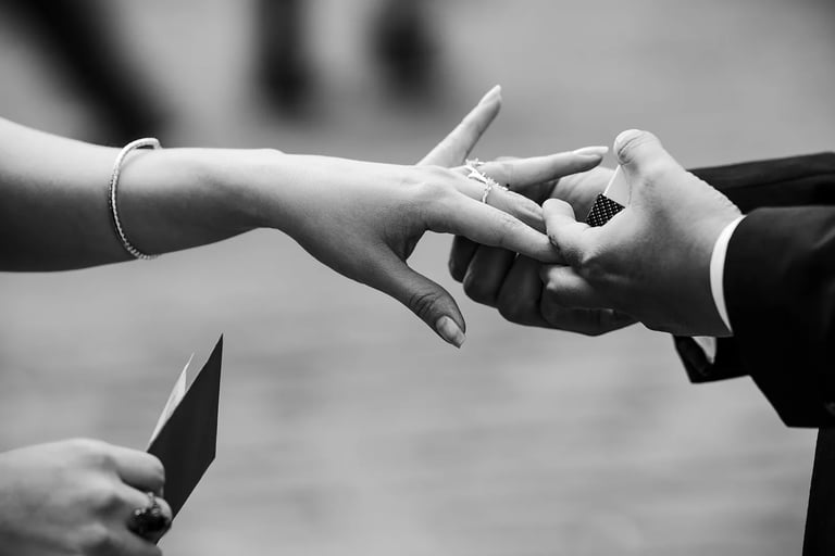 Plano detalle de novio colocándole el anillo a su novia en el dedo