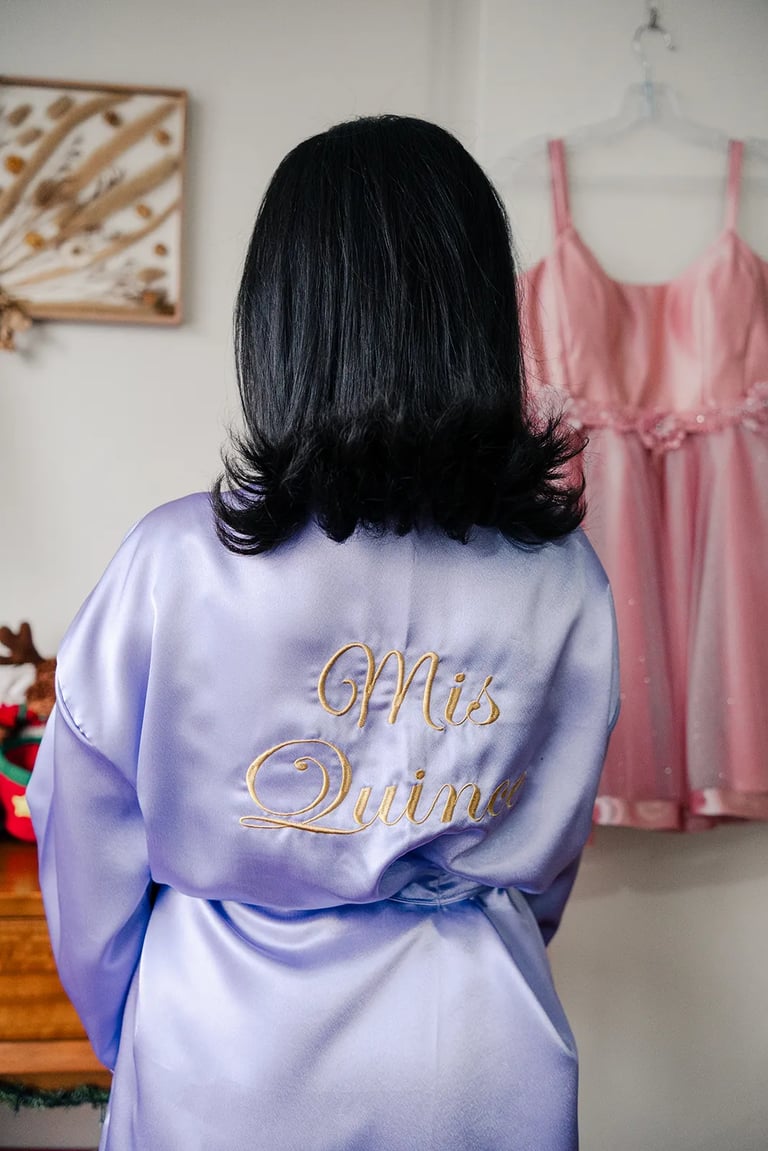 Quinceañera con su bata morada y su vestido de fondo en Quito, Ecuador