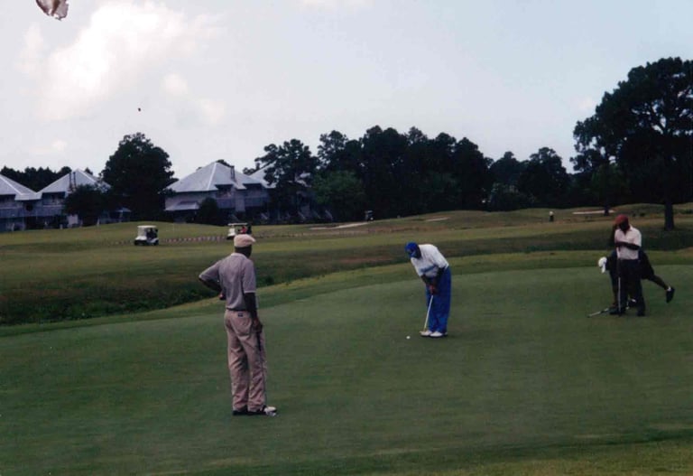 Par Four Golf Club image of group of black golfers putting.
