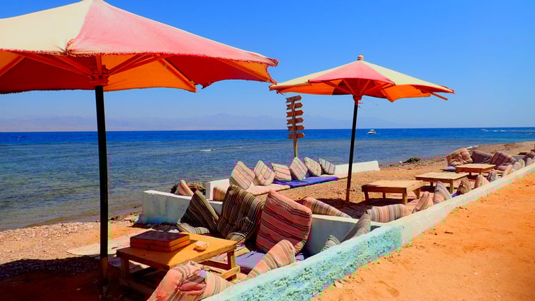 Lounge area with umbrellas in front of the Red sea at Bedouin star Egypt