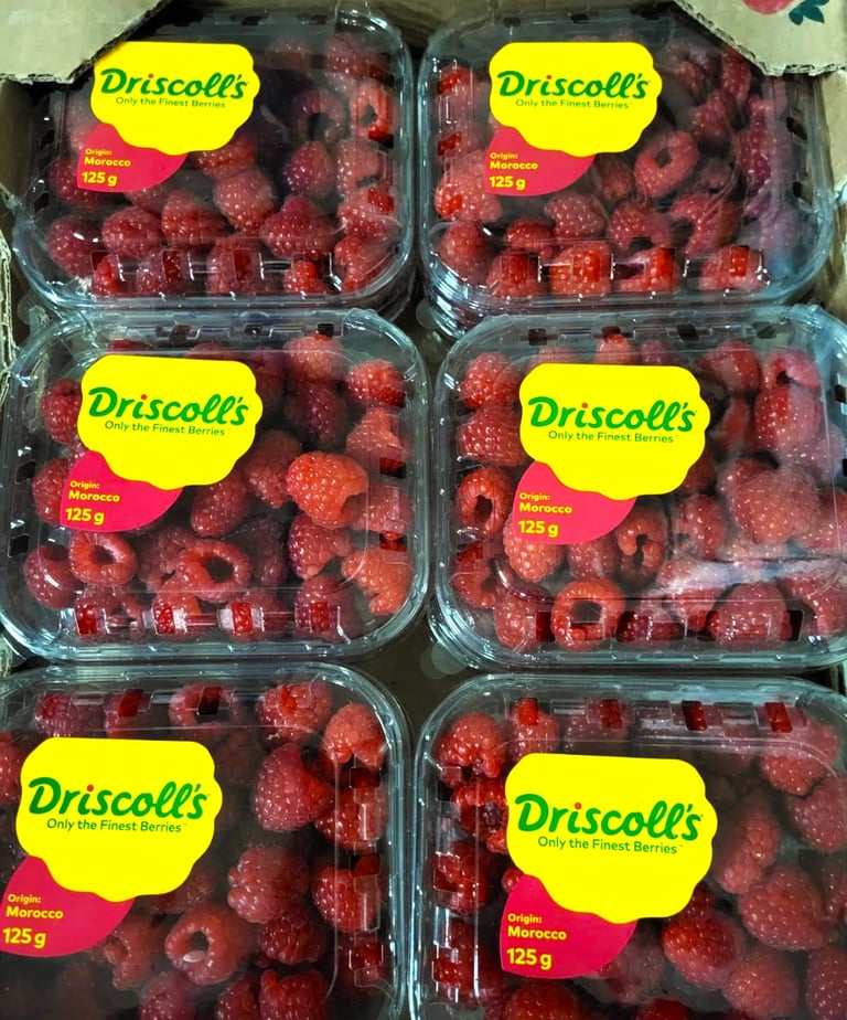 Czerwone maliny w pudełeczkach Driscoll's. Świeże owoce