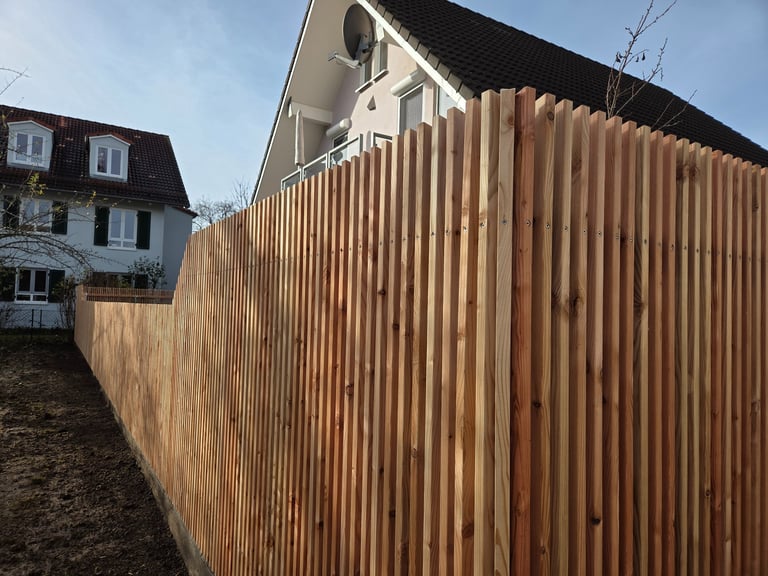 Moderner Sichtschutzzaun aus vertikalen Holzlamellen im Garten von Holztechnik Volk am Ammersee