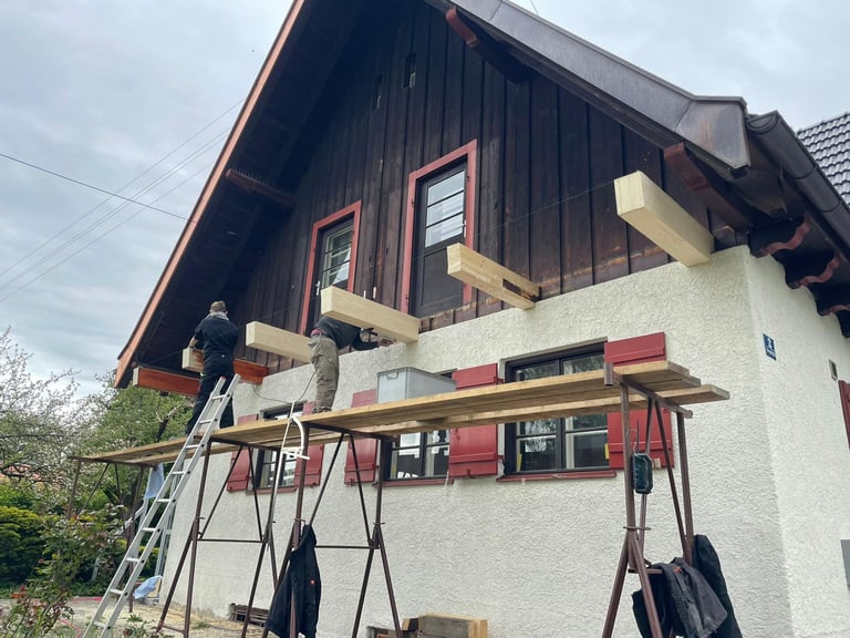 Montage neuer Holzbalken für einen Balkonanbau an einer Hausfassade durch Holztechnik Volk am Ammersee