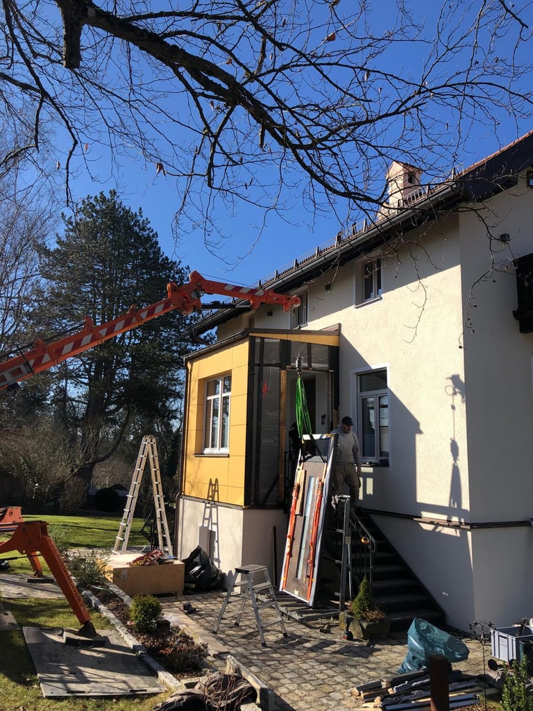 Kranarbeiten bei der Montage eines schweren Bauelements am Hauseingang durch Holztechnik Volk am Ammersee
