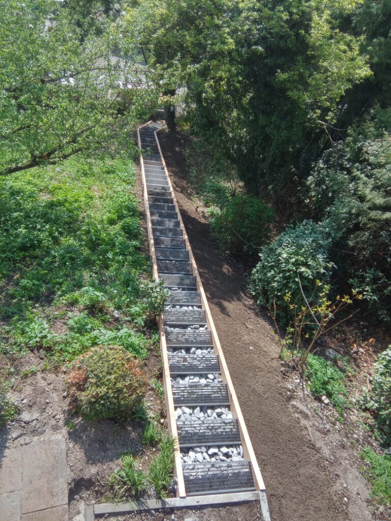 Lange Gartentreppe in Hanglage mit Holzkonstruktion und Gitterrosten von Holztechnik Volk am Ammersee