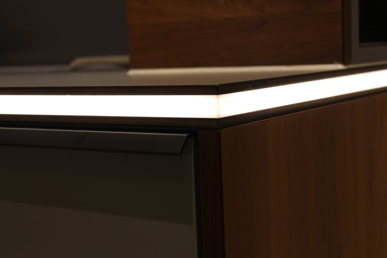 Detailansicht des sauberen Materialübergangs zwischen massiver Holzplatte und dunkler Stein-Arbeitsplatte.