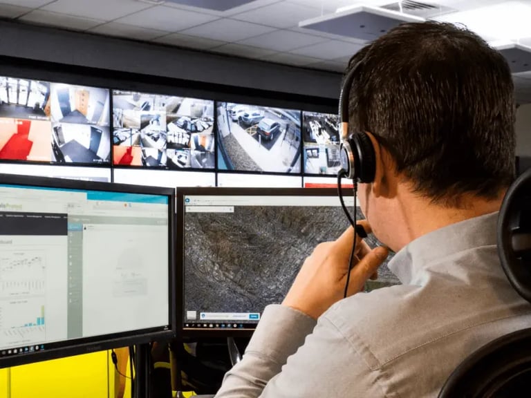Security professional monitors live surveillance Manchester camera feeds in a central control room.