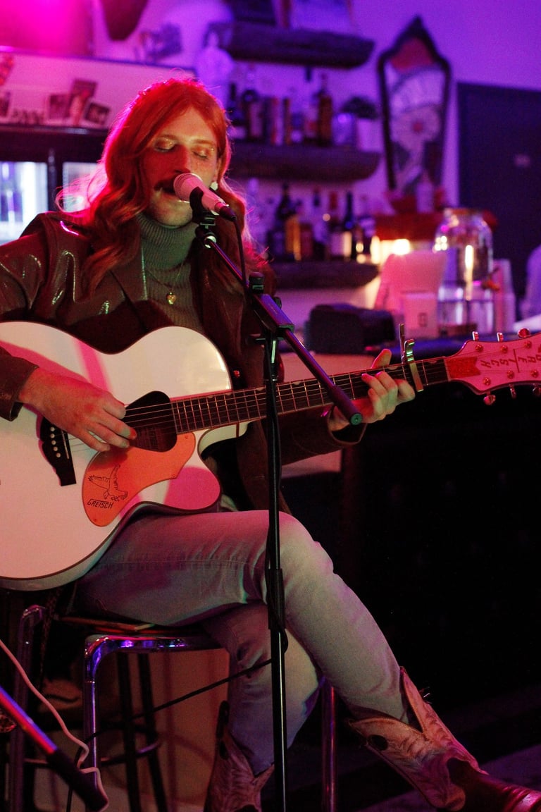 Robert Adam performing with a guitar at the Ill-Fated Kustoms event space in 2023.