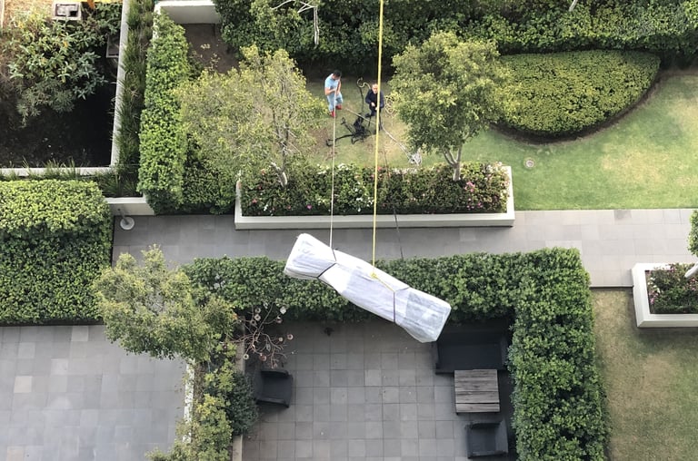 Personal de AVM Mudanzas volando mueble de gran formato en Santa Fe de la Ciudad de México.