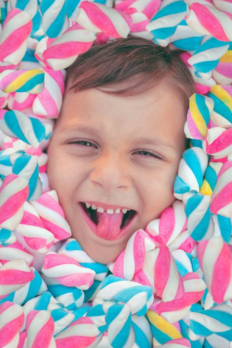 NIÑO SONRIENTE ENTRE BOMBONES