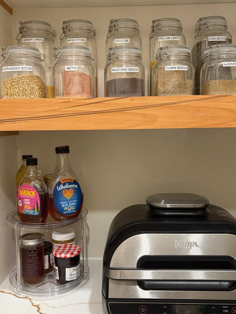 Kitchen spice organization with labeled glass jars for a clean and functional kitchen storage system