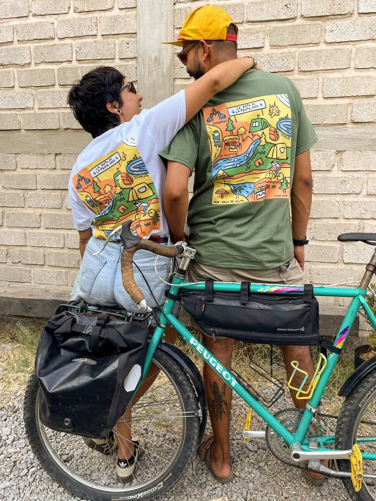 Pareja de ciclistas usando playera ilustrada de un recorrido turístico en bicicleta.