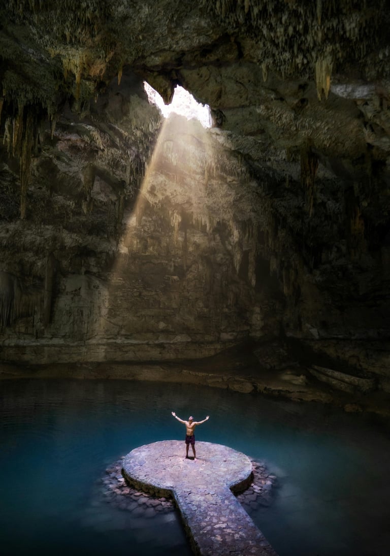 Cenote en Riviera Maya con entrada de luz y persona parada en una plataforma