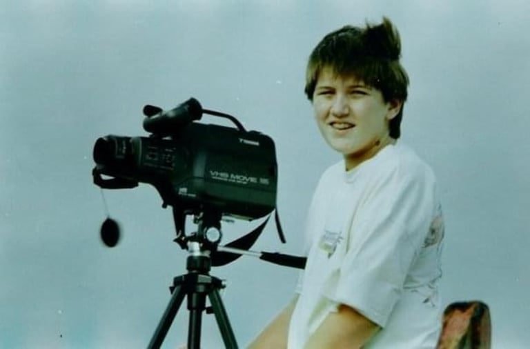 Andy next to a VHS movie camera mounted on a tripod.