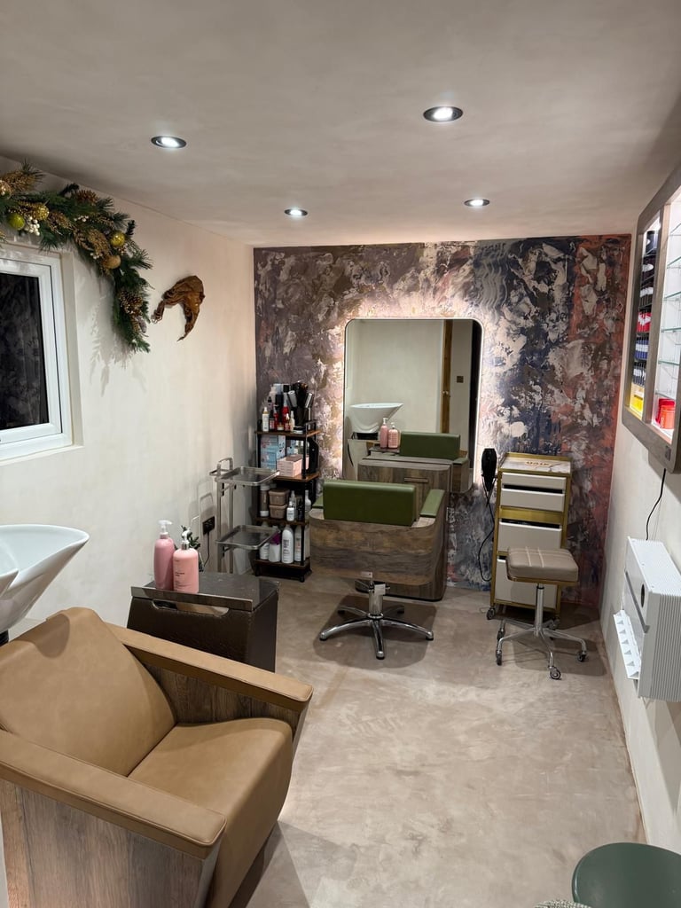 Modern interior of a hair salon finished with microcement, featuring professional chairs, a washbar.