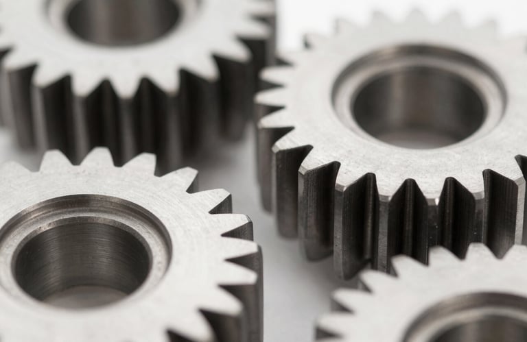 Macro photography of perfectly machined steel automotive gears. Sharp focus, clean lighting emphasizing the texture and precision, with a cool professional color palette including #F9F9F9 and dark steel #1A1A1A.