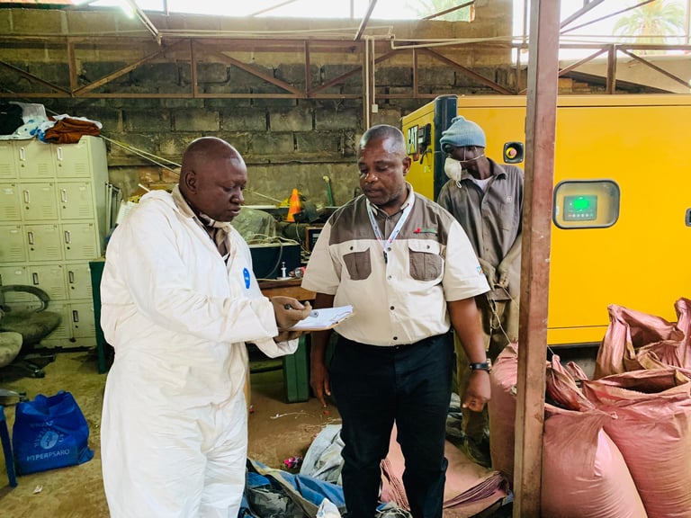 Technicians in protective gear performing a safety inspection on industrial equipment in a warehouse.