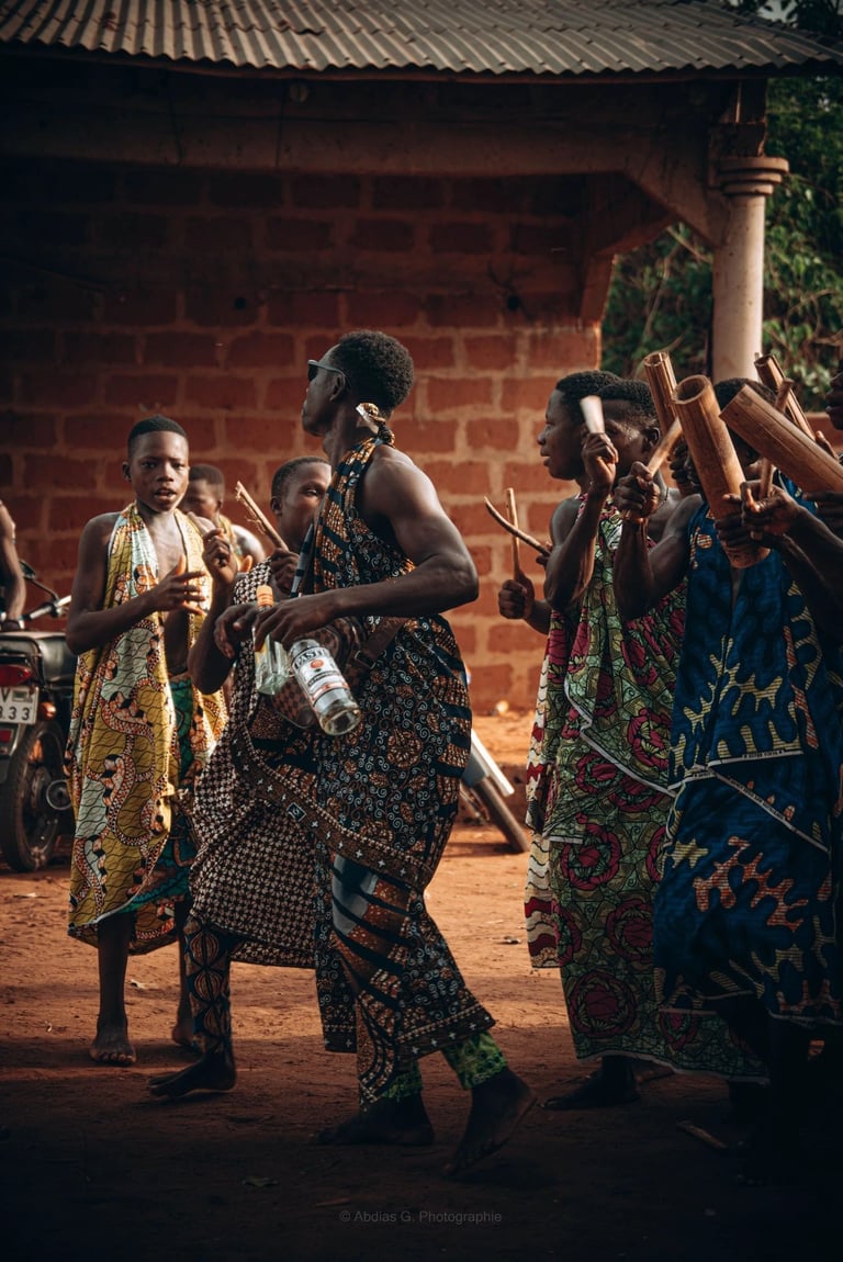 Groupe de femmes dans un village africain, dansant ensemble avec des mouvements rythmés et des sourires éclatants.