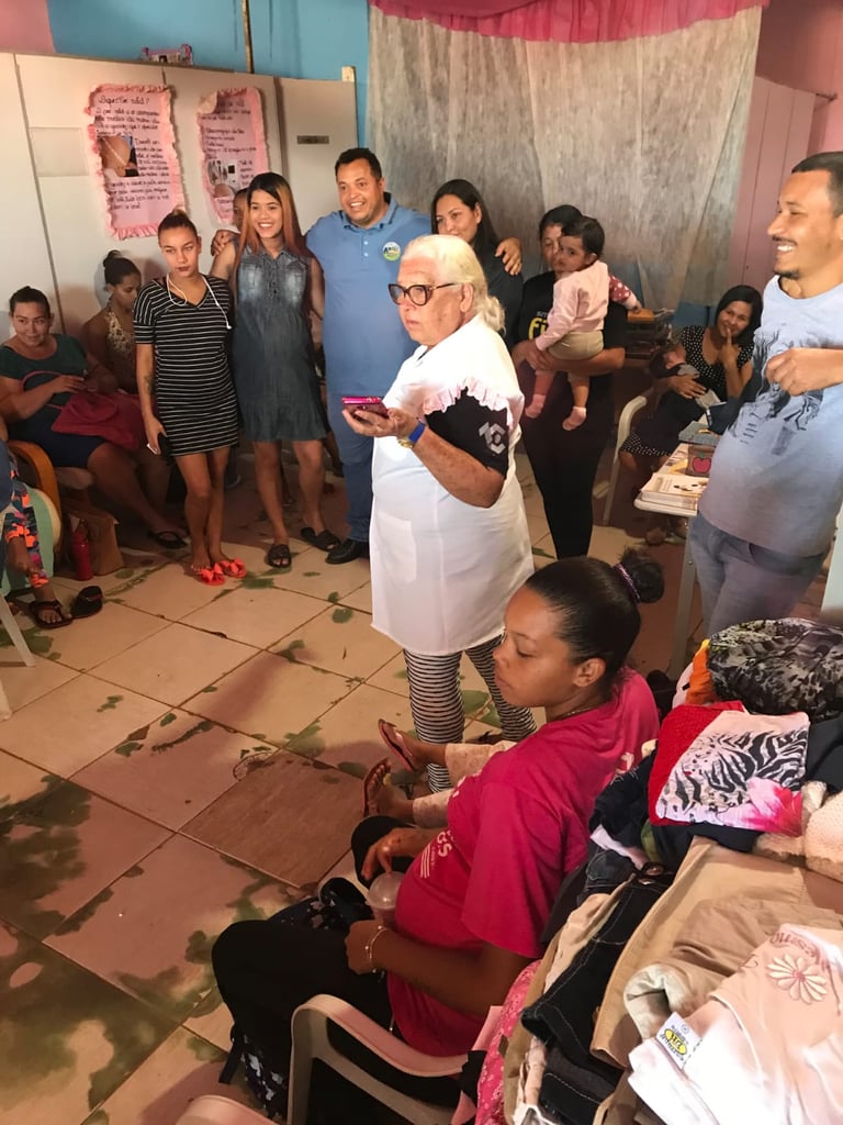 Community gathering with an instructor leading a social support group for women and families indoors.