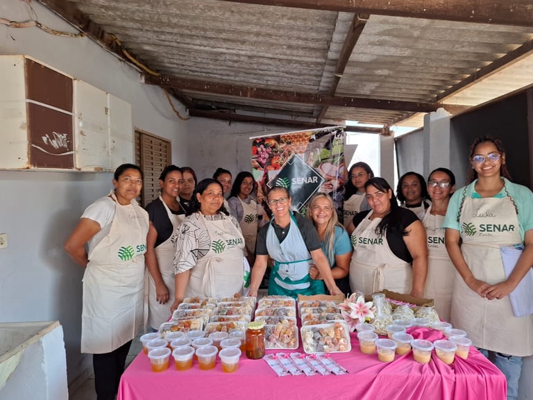 Group of women in SENAR aprons showcasing artisanal food products at a rural training workshop.