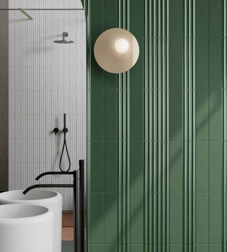 Modern bathroom featuring forest green fluted wall tiles and a round designer wall sconce.