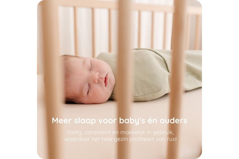 Baby in een Puckababy inbakerzak in een houten ledikant