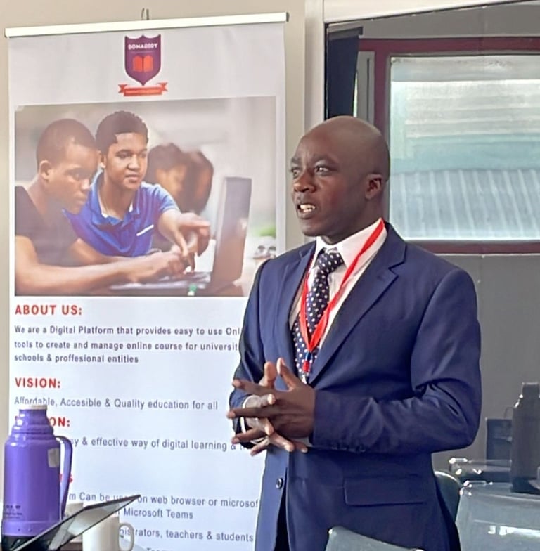 A male speaker in a suit presenting digital education tools next to a Somademy banner.