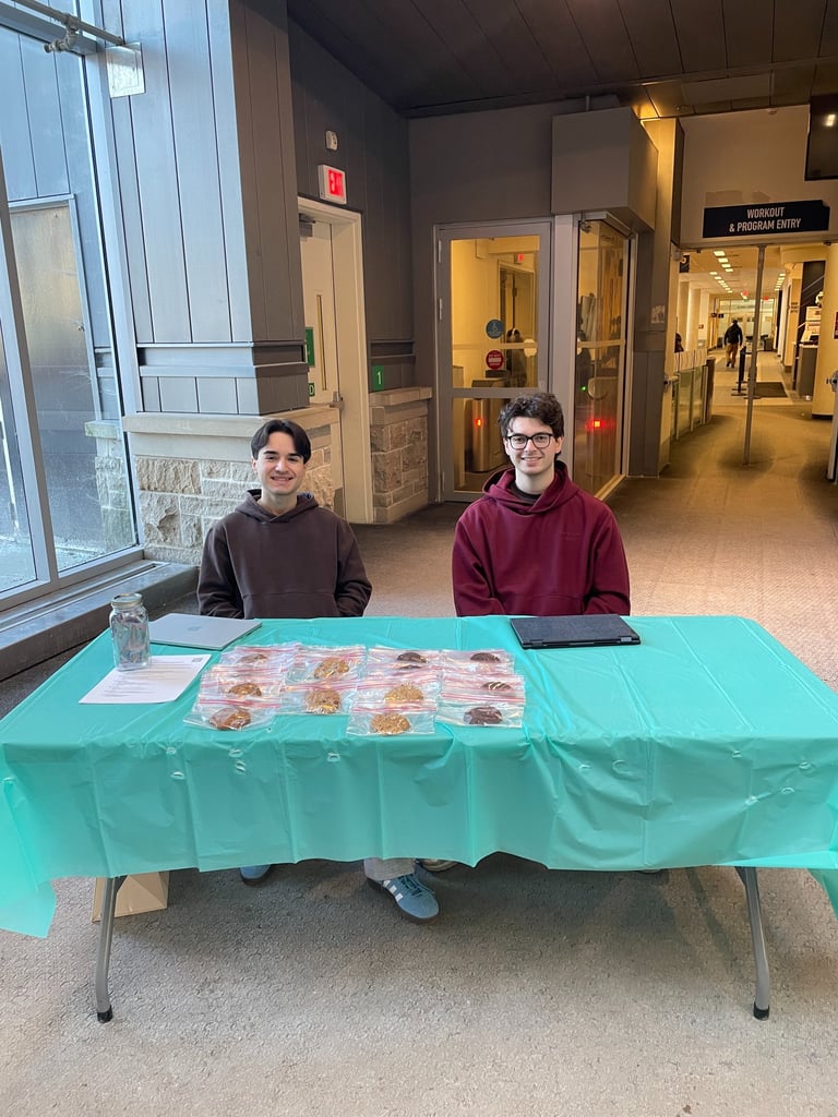 Two student sit in the Queen's Athletics and Recreation Centre ready to answer questions