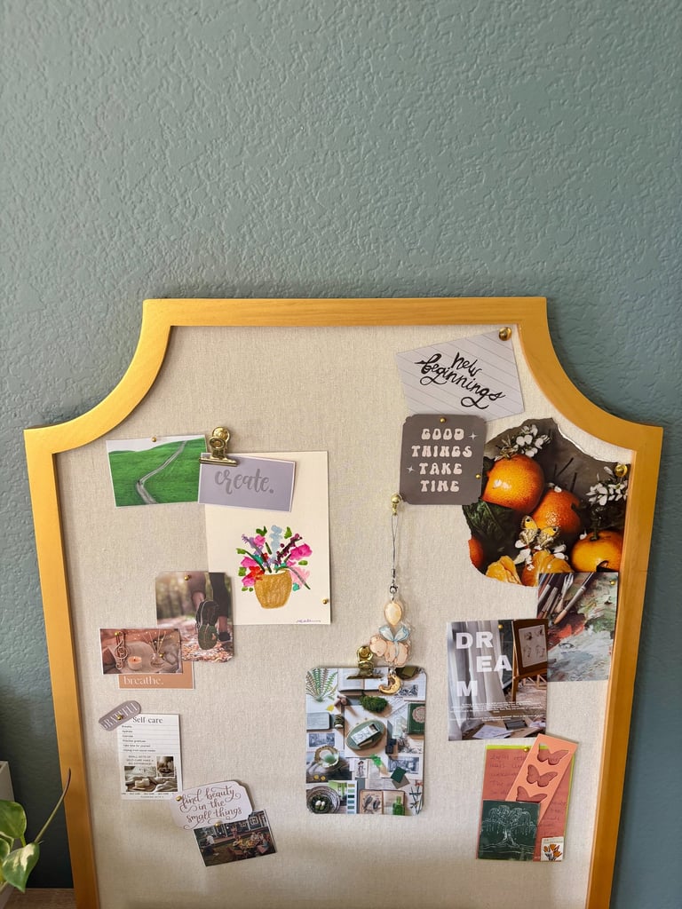 Gold-framed vision board with inspirational quotes, aesthetic photos, and creative art on a linen background.