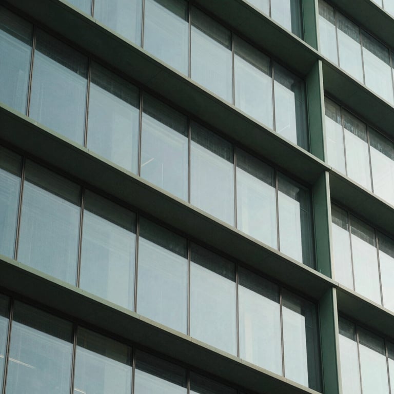 Architectural detail of a sleek building facade featuring glass and steel accents in sage green tones, daylight, professional clean lines.