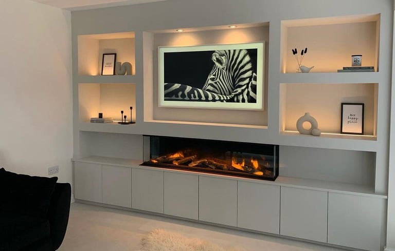 Custom media wall installation with shelving, built-in storage, and ambient lighting