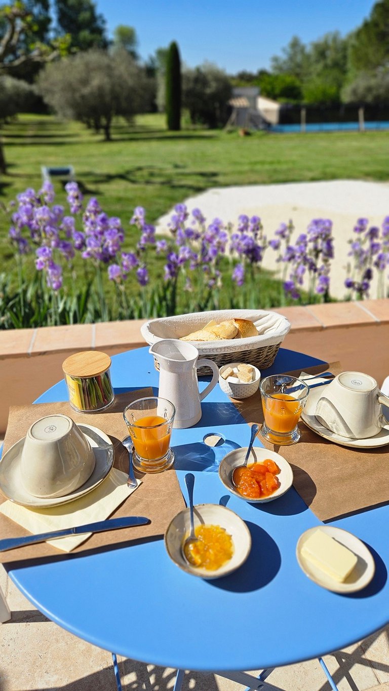 petite table ronde extérieur dressée du petit-déjeuner, tasses confiture, jus, thé, etc...