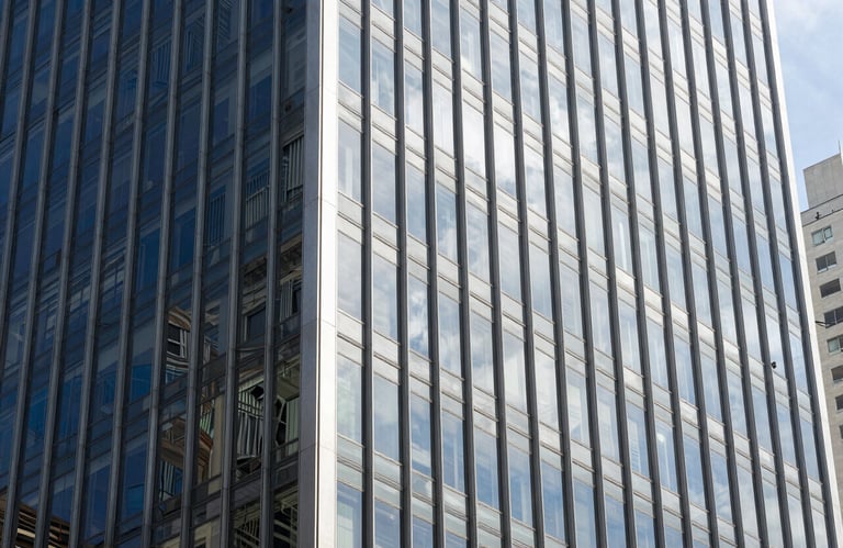 Modern architectural detail of a glass corporate building in a Brazilian business district, midday sun, clean and professional look with silver and navy blue tones.