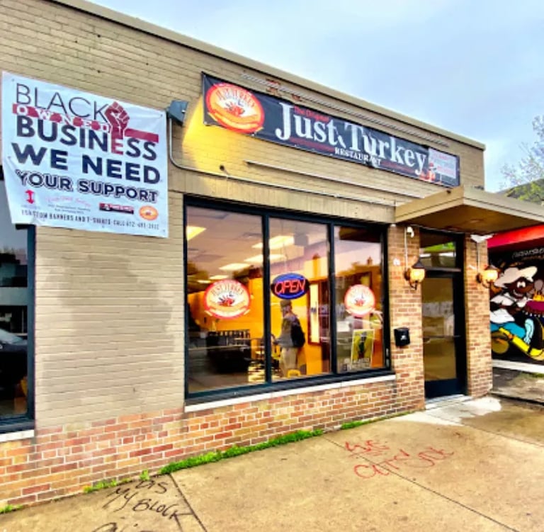Just Turkey restaurant exterior with a black-owned business support banner and neon open sign.